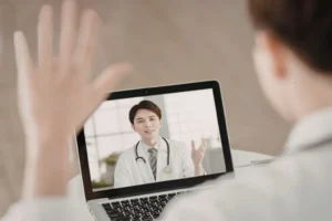 Clinician on a secure video appointment with a client, laptop on a desk
Clinician on a secure video appointment with a client, laptop on a desk